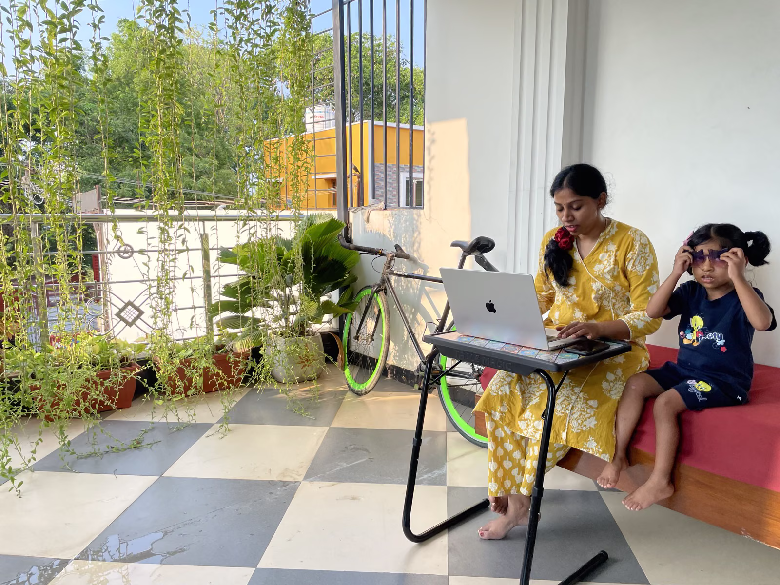 Parent working remotely while spending time with a child at Nivaa Stays — family-friendly workation setting